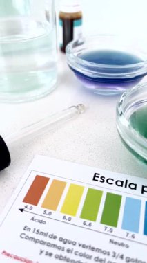Renk göstergeleri kullanılarak filtrelenmiş su ve musluk suyunun yan yana pH testini gösteren video asitlik veya alkalite farkını ortaya koyuyor