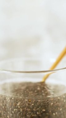 Chia tohumlarının suda asılı ve genişlediğini gösteren dikey video doğal jel dokusunu vurguluyor..