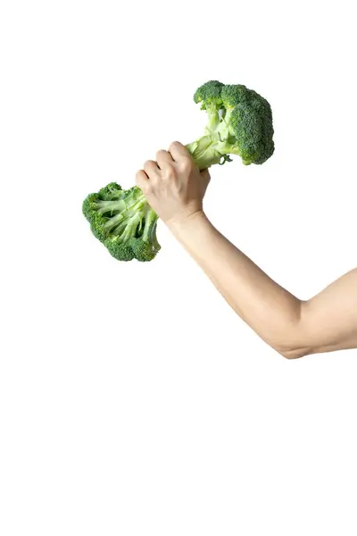 Yaratıcı fitness temalı görüntü iki brokoliyi halter gibi tutan bir eli gösteriyor..