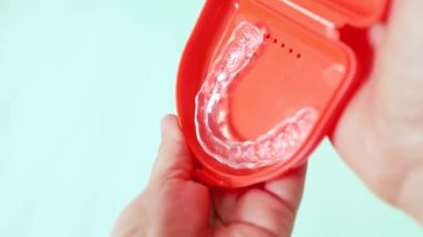 Diş gıcırdatmasını ve bruksizmden kaynaklanan çene gerilimini önlemek için tasarlanmış bir diş gece bekçisini (oklusal atel) gösteren video.