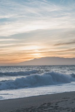 Güneş batarken Cabo de Cabo de Gata-Nijar Doğal Parkı, Almerya 'da bulunan La Fabriquilla Sahili' nin sıcak ve sakin bir manzarası.