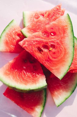 Pastel pembe arka planda taze karpuz dilimleri, en az yaz meyvesi konsepti.