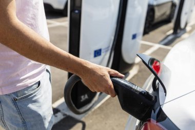 Bir şarj istasyonuna bağlı modern elektrikli araç, temiz enerji konsepti, sürdürülebilirlik, çevre dostu ulaşım ve gelecekteki hareketlilik