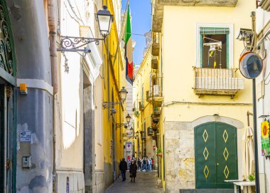 Nisan 04 2022 - Napoli İtalya - Kalabalık bir cadde Bir sürü scooterla ve insanlar eski renkli binaların önünden geçmek için yürüyorlar