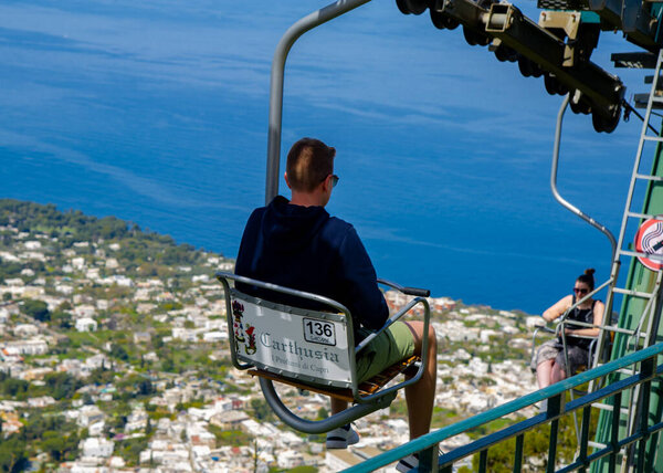 24 апреля 2022- Анакапри Италия вид с канатной дороги с большим количеством туристов, идущих вверх и вниз и голубое небо, лазурное море на заднем плане