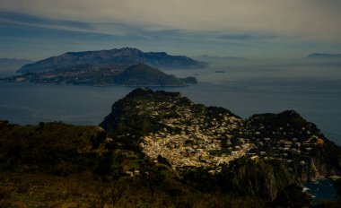 View from a cliff on the island of Capri, Italy, and rocks in the sea, blue sky and beautiful gardens
