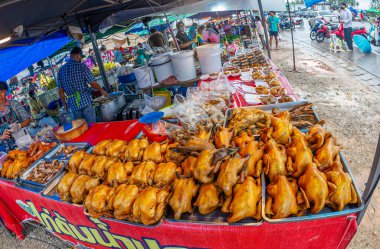 24 Ocak 2023 'te Chumphon Tayland' da tezgahın arkasında maskeli bir tavuk satan kalabalık bir pazar..