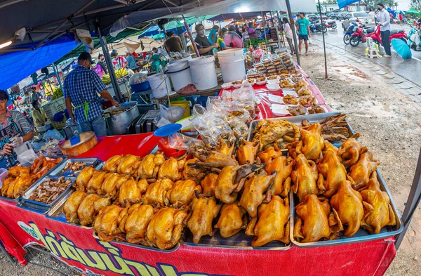 24 Ocak 2023 'te Chumphon Tayland' da tezgahın arkasında maskeli bir tavuk satan kalabalık bir pazar..