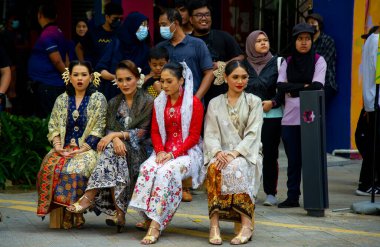 Şubat-20-2023 - Kuala Lumpur Malezya - Çok sayıda izleyicisi olan parlak renkli halk kıyafetleri giyecek gençlerle sokakta evlilik öncesi dans.