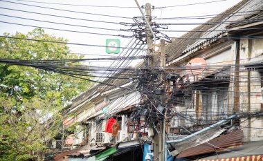 Direkte dağınık elektrik ve internet kabloları Tayland 'da bir elektrik direğindeki kablolar ve kablolar.
