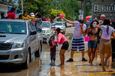 13 Nisan 2023-Thung Wua Laen Sahili - Chumphon bölgesi: Kalabalıklar Songkran, Tayland Yeni Yılı 'nı birbirlerini renkli suyla ya da renkli kremayla boyayarak kutluyor.