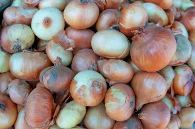 Bir market tezgahındaki soğan yığınına yakın çekim.
