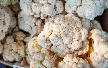 Bir market tezgahındaki karnabahar yığınına yakın çekim.