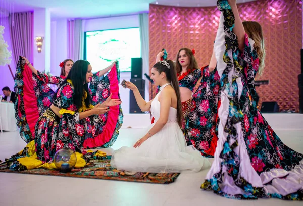 stock image June- 2023 03- Bucharest-Romania- The bride during her wedding has fun and dances with the entertainers who are dressed multicolored