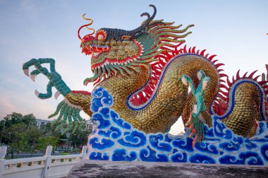 Suan Sawan 'da ya da Tayland Nakhon Sawan' daki Cennet Parkı 'nda inşa edilmiş güzel detaylandırılmış altın dans eden ejderha.