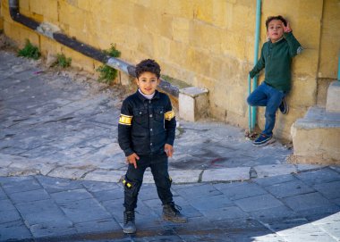 26 Aralık 2021-AS-Tuz Ürdün çocukları, aynı zamanda ülkenin idari merkezi olan eski kentin kaldırımlı sokaklarında oynuyorlar..