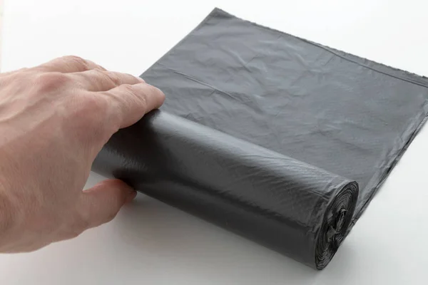 Hand Slingert Een Rol Plastic Vuilniszakken Een Zwarte Polyethyleen Afvalcontainer — Stockfoto