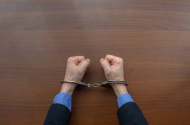 Polis merkezinde tutuklu bir suçlunun elleri kelepçeliydi. Boşluğu kopyala