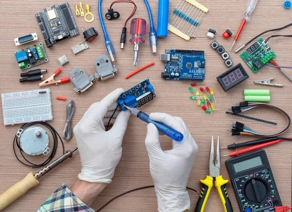 Ręce Inżyniera Montują Deskę Chleba Mikrokontrolera Arduino Otoczonego Elektronarzędziami Strojenia — Zdjęcie stockowe