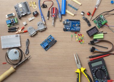 Çevresel ve genişleme tahtaları olan elektronik bir laboratuvar masasının üst görüntüsü. Elektronik ayar araçlarıyla çevrili bir Arduino mikro denetleyicisinden bir robot düzeni monte etmek.