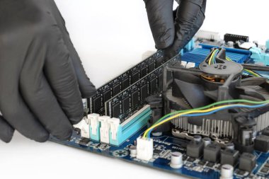 Teknisyen RAM 'i bir bilgisayarın ana ana ana kart yuvasında ısıtıcılarla kurar ya da değiştirir.