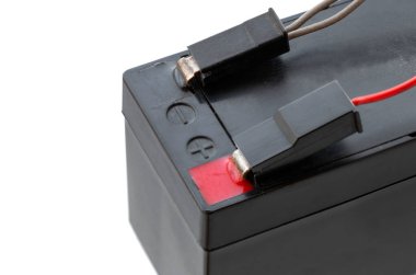 Pimlere bağlı kabloyla asitle şarj edilebilir batarya, yakın plan, beyaz zemin üzerinde izole edilmiş.