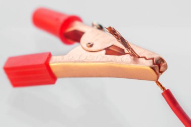 Çıplak tele bağlı kırmızı klemp, makro, beyaz üzerinde izole edilmiş.