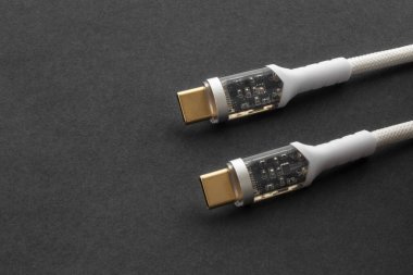 Bilgisayarı cihazlarla şarj etmek ve senkronize etmek için modern bir konnektörü olan evrensel USB tip-C 100 W kablo. Kopyalama alanı olan gri bir arkaplanda.