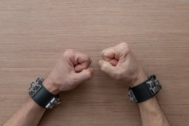 Yumruklarını sıkmış insan elleri ve sivri uçlu deri bilezikler takıyor. Rock 'çılar, motorcular, metal kafalar, gotikler ve serseriler için aksesuarlar. Steampunk tarzı. Üst görünüm, kopyalama alanı ile.