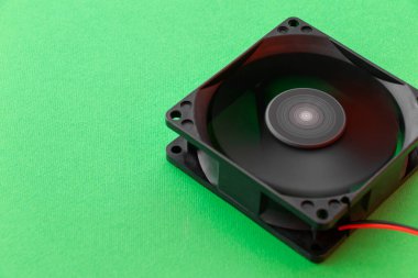 rotating vector computer fan, 12 volt, on green background. with copy space