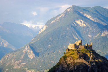 Tourbillon Kalesi 'nin Görkemli Harabeleri: İsviçre' nin Sion şehrinde nefes kesici bir dağ manzarası arasında tarihi bir mucize. Arka planda yükselen dağlar