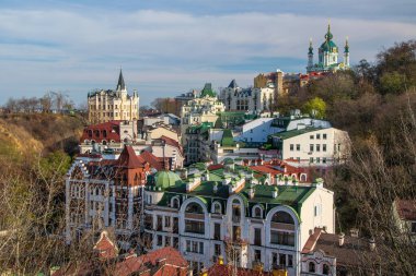 Kyiv 'deki Andriivsky Descent' in renkli şehir manzarası, çeşitli mimari özellikleri barındırıyor ve ikonik St. Andrew Kilisesi tarafından taçlandırılıyor. Ukrayna 'nın Kyiv yamacındaki tarihi ve modern binaların bir karışımı.