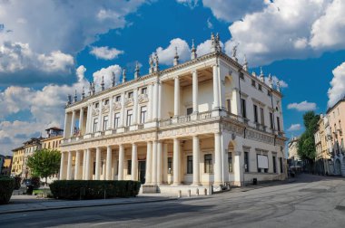 İtalya 'nın Vicenza kentindeki bir Rönesans başyapıtı olan Palazzo Chiericati' nin aydınlık manzarası. Sütunları ve heykelleri olan zarif beyaz cephe kabarık bulutlu canlı mavi gökyüzüne karşı duruyor.