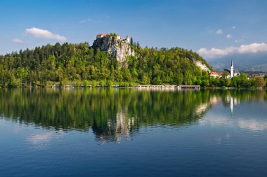 Bled Kalesi 'nin manzarası Bled Gölü' nü yansıtıyor, Slovenya 'nın Bled Adası' ndaki Maria 'nın Hacı Kilisesi' nin haccıyla