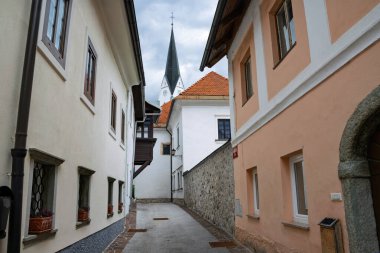 Slovenya 'nın eski Radovljica kentinde, kiliseye giden dar bir sokağa sahip geleneksel mimari