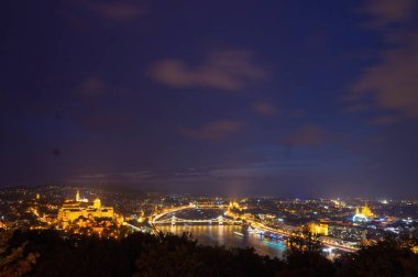 Budapeşte 'nin geceleri parlayan panoramik manzarası, Budapeşte Kalesi, Zincir Köprüsü ve Macaristan' ın Citadella perspektifinden görünen Macar Parlamento Binası aydınlandı
