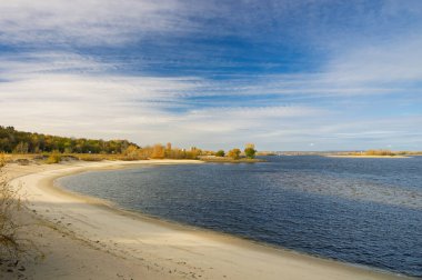 Ukrayna 'nın Kaniv kentinde güneşli bir sonbahar gününde akan Geniş Dinyeper Nehri, sakin ve sakin bir sahil ve manzaralı bir manzara oluşturan sakin sulara sahiptir.
