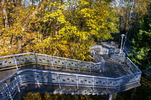 Metal stairway with decorative railing leading to the Taras Shevchenko Grave on Chernecha Hill in Kaniv, Ukraine, surrounded by colorful autumn foliage