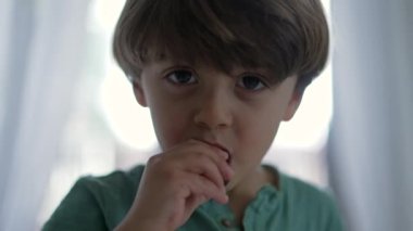 Çikolata yiyen küçük bir çocuğun portresi. Mutlu bir çocuk tatlı yer.