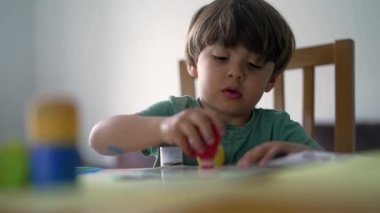 Çocuk evde yaratıcılık aktivitesi boyuyor. Sanatçı çocuk resim yapıyor.