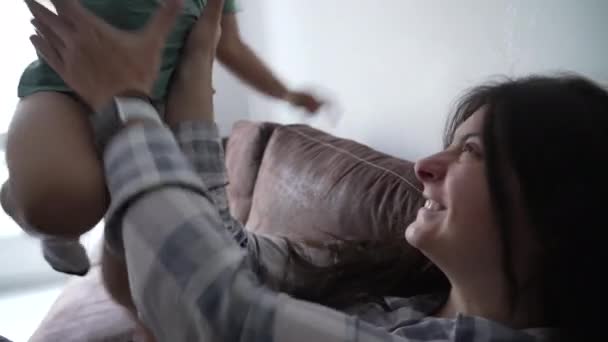 母亲和孩子真正的互动拥抱在沙发上 小男孩带着妈妈的爱和感情 — 图库视频影像