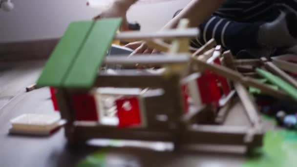 用小型推土机拖拉机摧毁木制家居用品的孩子 一个小男孩的驱逐舰在家里的游戏室里玩耍 — 图库视频影像