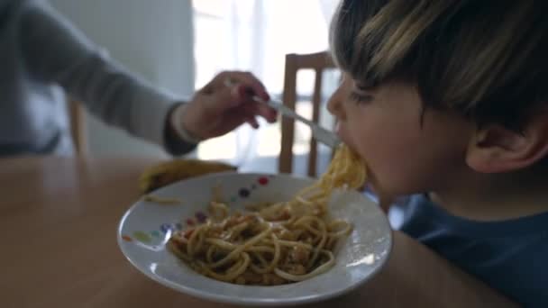 시간에 엄마가 스파게티 파스타를 아들에게 먹였어요 부모는 집에서 포크로 아이에게 — 비디오
