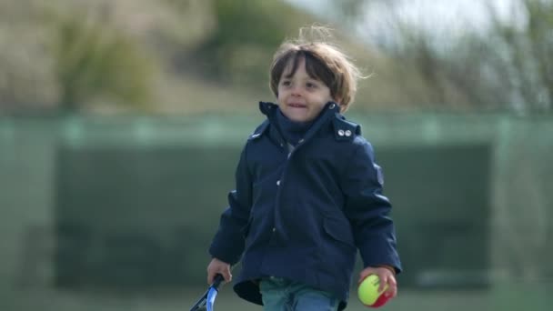 Een Jongetje Met Een Tennisracket Buiten — Stockvideo
