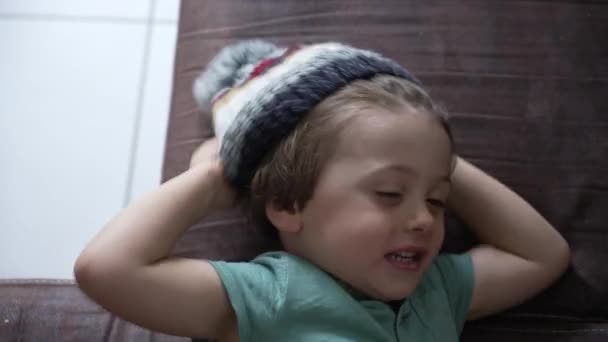 Ein Kind Legt Eine Mütze Ins Haus Niedlicher Kleiner Junge — Stockvideo