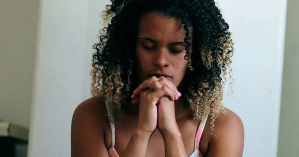 Black woman praying to God during difficult times
