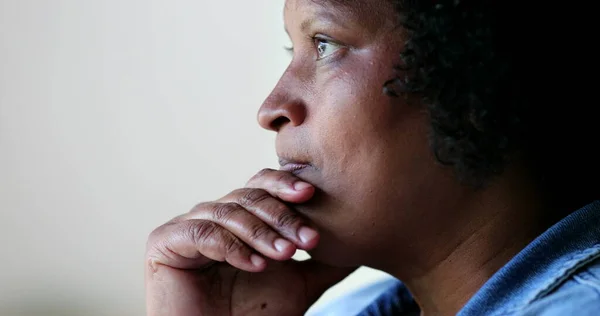 Anxious African woman toching face in anxiety, worried pensive emotion