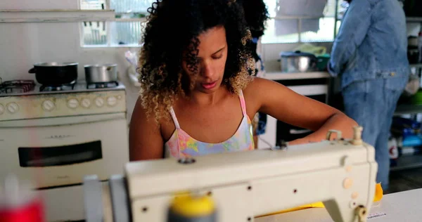 Entrepreneur black woman working from home knitting on machine
