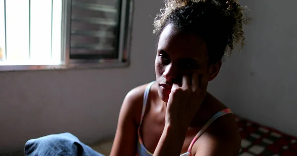 Bunalımlı siyah kadın evde tek başına oturuyor.