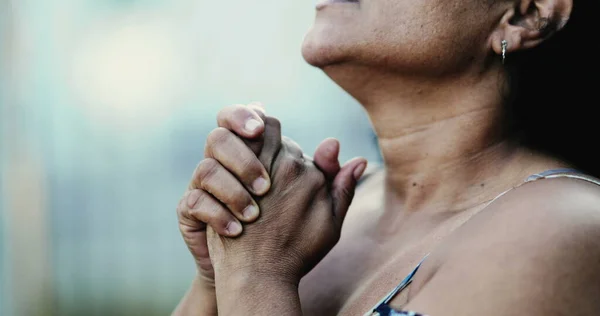 Hispanic black woman praying to God, close-up hand